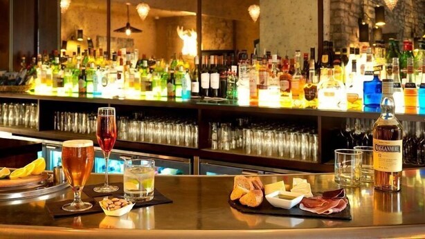 A bar area with a variety of bottles and glasses, a selection of cheeses and meats, and a bottle of Calignone. - The Abergavenny Hotel  (Abergavenny)