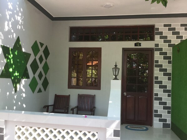 A room with a white ceiling, a wooden door, two windows, and a small table with chairs. - Mui Ne Village Resort (Mui Ne)