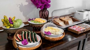 A breakfast buffet with various fruits, bread, and a toaster. - Lee Chiang Hotel (Chiang Mai)