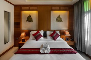 A neatly made bed with white linens, two red pillows, and a red and gold throw blanket. There are two bedside lamps, a wooden nightstand, and a framed picture on the wall. - Lee Chiang Hotel (Chiang Mai)