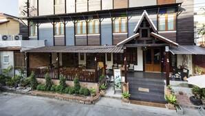 A two-story building with a covered outdoor seating area and a small entrance. - Lee Chiang Hotel (Chiang Mai)