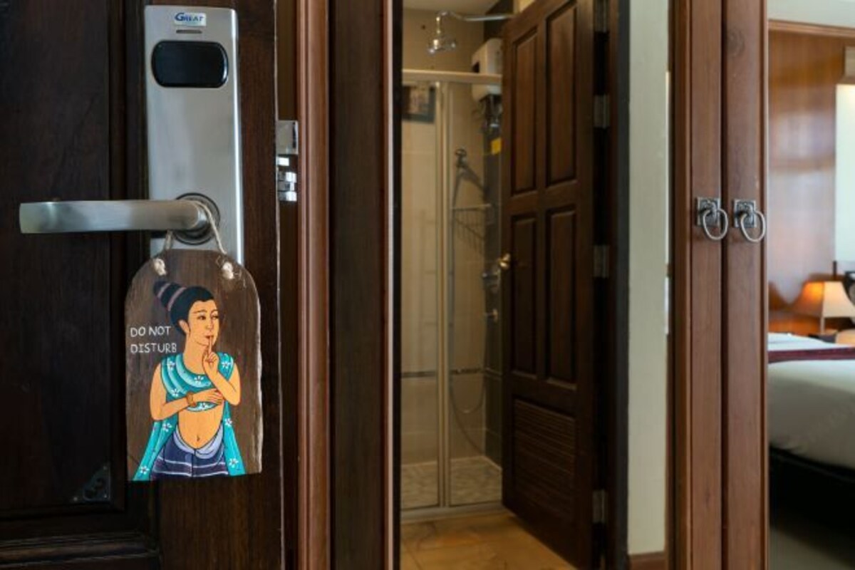 A hotel room entrance with a door featuring a 'DO NOT DISTURB' sign and a keycard slot.