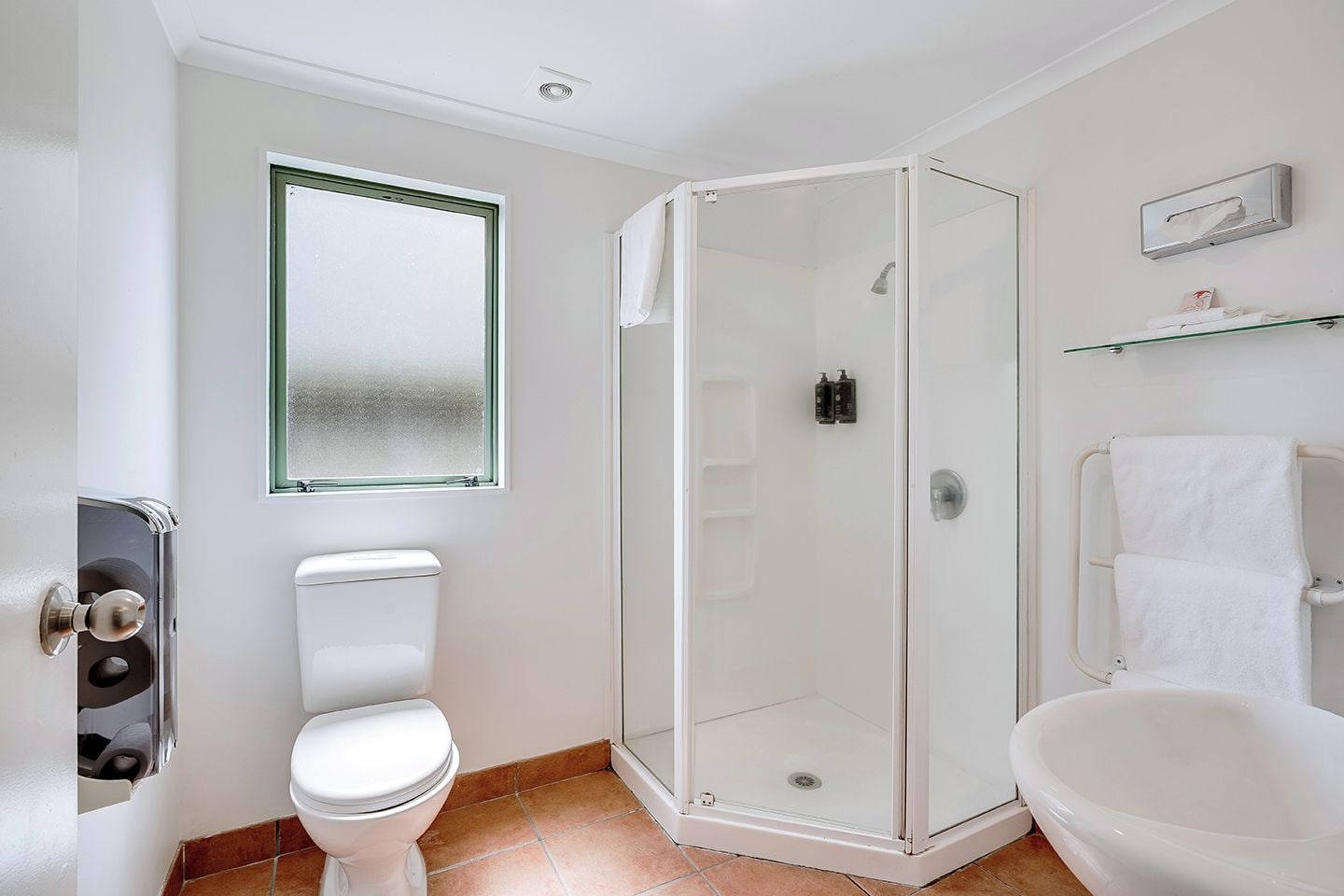 Een badkamer met toilet, douchecabine en bad.