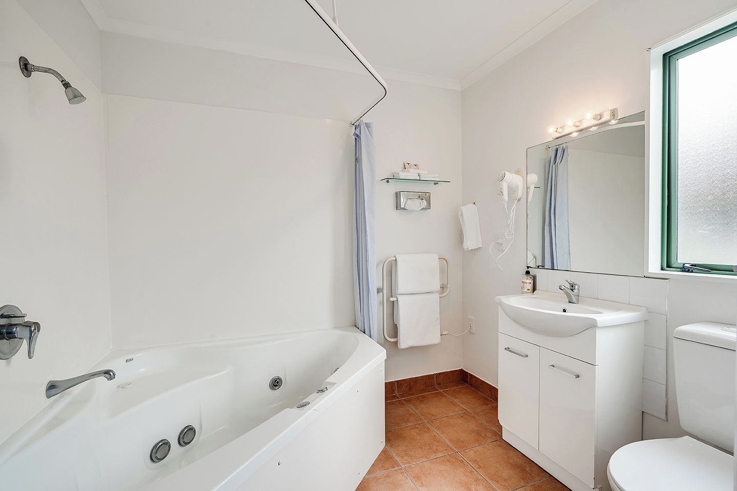 A modern bathroom with a bathtub, a sink, a toilet, and a shower.