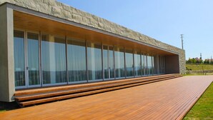 A modern building with a long, wooden deck extending from the structure. - Lousada Country Hotel (Lousada)