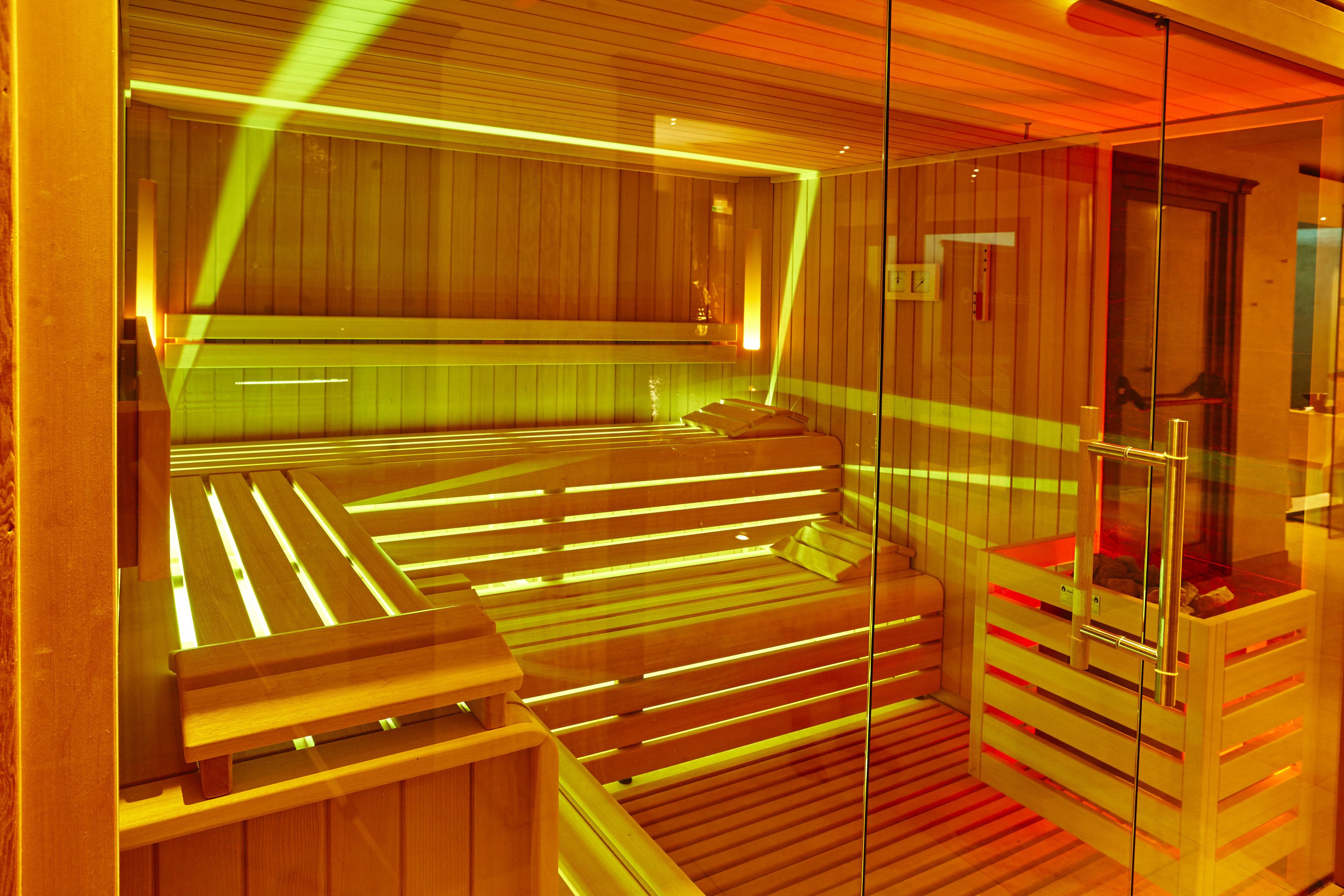 A sauna with wooden benches and glass walls.