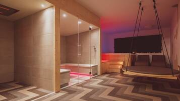 Une salle de spa moderne avec un plancher en bois, une douche en verre, un plancher chauffant et un fauteuil suspendu.
