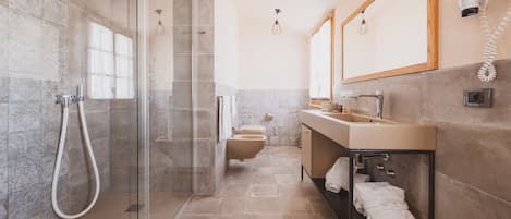 A modern bathroom with a glass-enclosed shower, a vanity with a mirror, and a toilet.