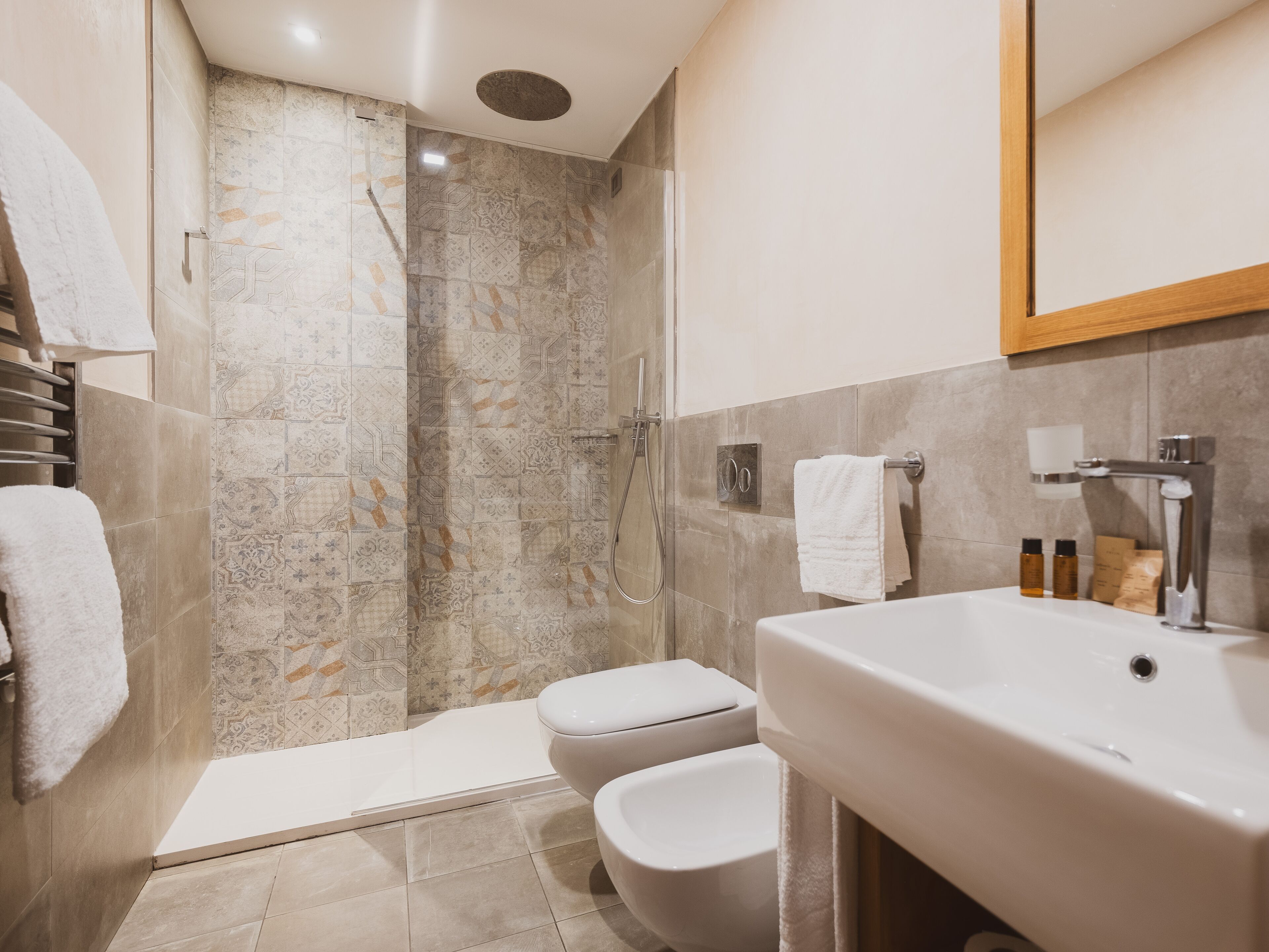 A modern bathroom with a shower, toilet, and sink.
