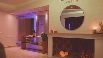 A hotel lobby with a reception desk, a fireplace, and a mirror on the wall.