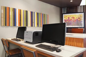 Un espacio de trabajo con dos monitores, un teclado y una impresora sobre un escritorio.