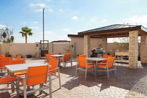 An outdoor patio with tables and chairs, a barbecue grill, and a pergola structure. - Holiday Inn Express & Suites Edinburg-McAllen Area by IHG (Edinburg)
