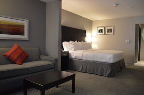 A hotel room with a bed, a sofa, a coffee table, and a nightstand. - Holiday Inn Express & Suites Tahlequah by IHG (Tahlequah)