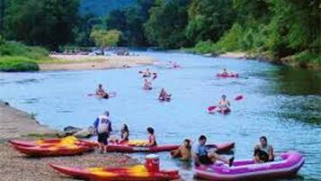 Un grupo de personas en kayaks y balsas inflables en un río.