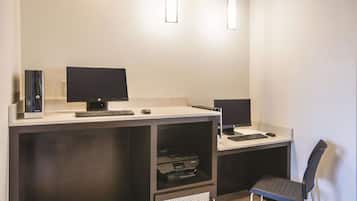 A modern office setup with two monitors, a printer, and a chair.