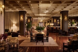 A spacious lobby with a central seating area, a staircase, and a bar/lounge area. - Pasadena Hotel & Pool (Pasadena)