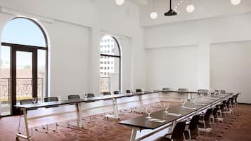 A conference room with a long table, chairs, and a projector.