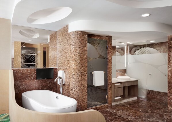 A modern bathroom with a freestanding bathtub, a vanity with a mirror, and a shower area.