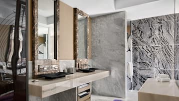 A modern bathroom with marble countertops, a double vanity, and a large mirror.