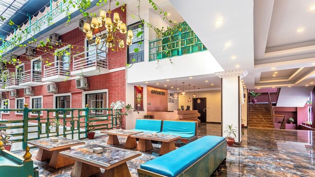 A spacious indoor area with multiple seating options, including benches and tables, and a staircase leading to an upper level. - Hotel Yukhang (Kathmandu)