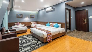 A hotel room with two beds, a sofa, a patterned rug, and an air conditioning unit. - Hotel Yukhang (Kathmandu)