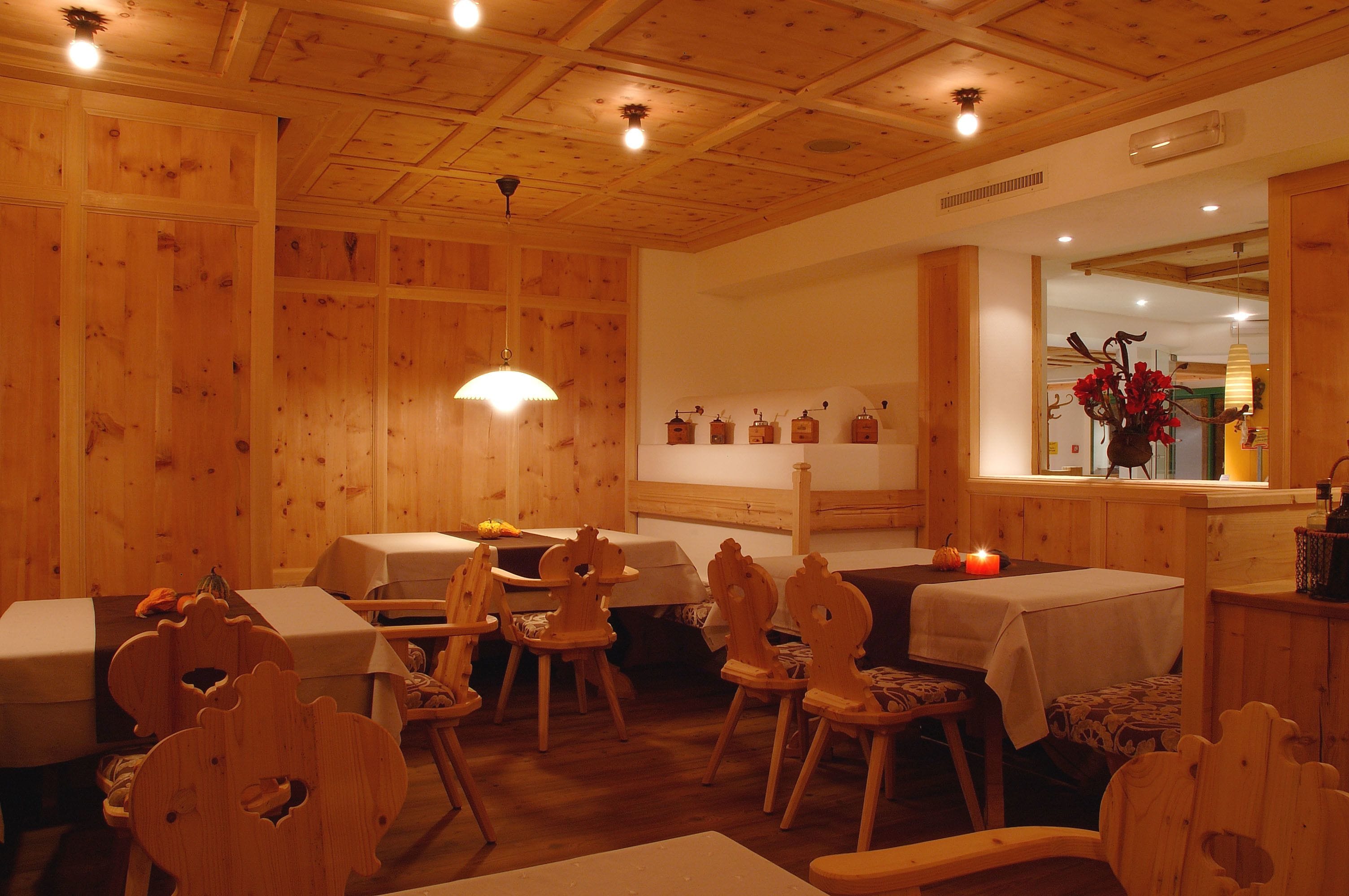 A cozy wooden interior with tables and chairs, a window with decorations, and a warm ambiance.