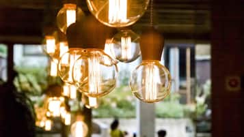 L’intérieur d’un restaurant, avec des luminaires sphériques suspendus et une vue sur la rue.
