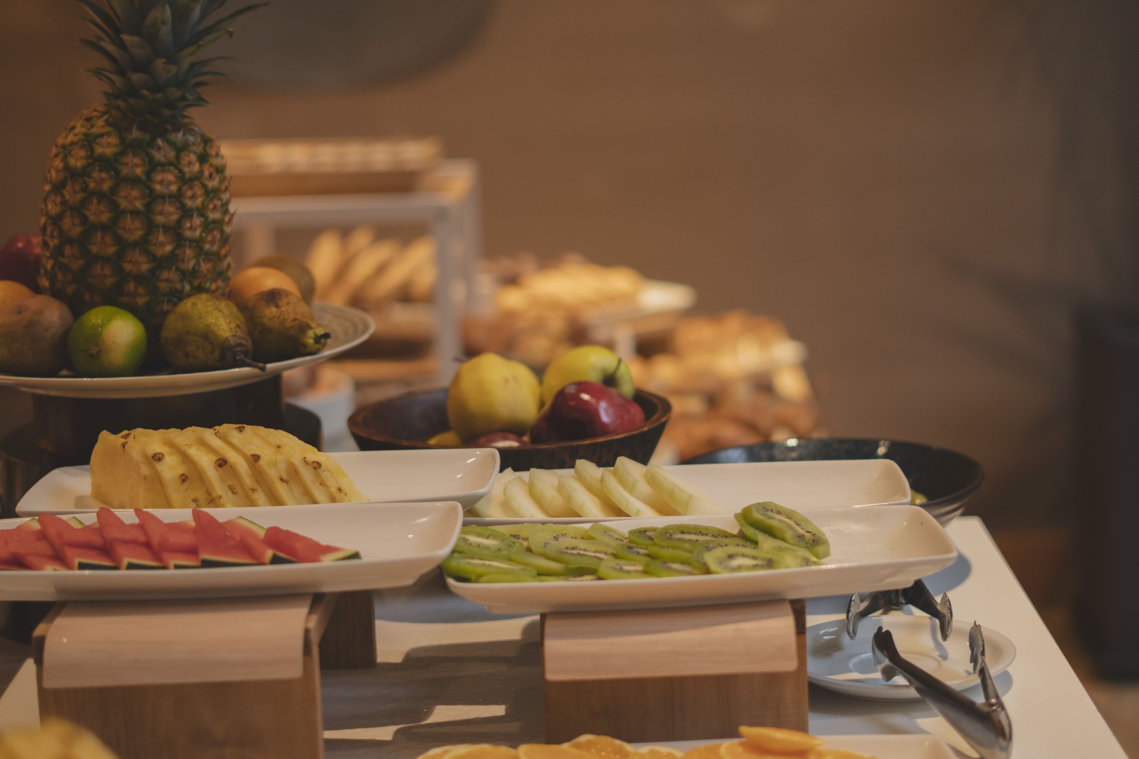 Un bufé con diversas frutas y pasteles.