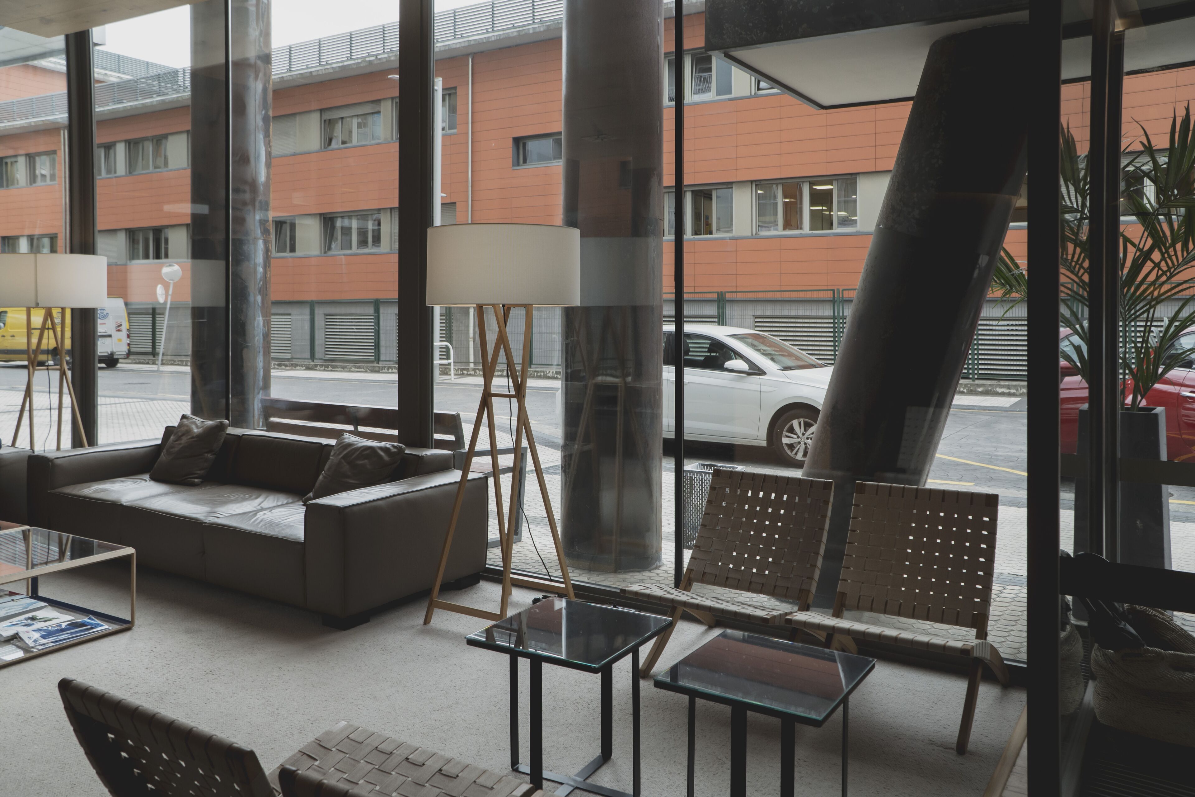 A modern interior with a sofa, chairs, and tables.