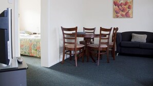 Un coin repas avec une table et des chaises, un téléviseur et un canapé.