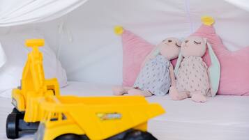 Una cama con peluches y un camión de juguete.