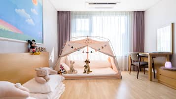 A child's room with a tent, plush toys, a bed, a desk, and a window with curtains.