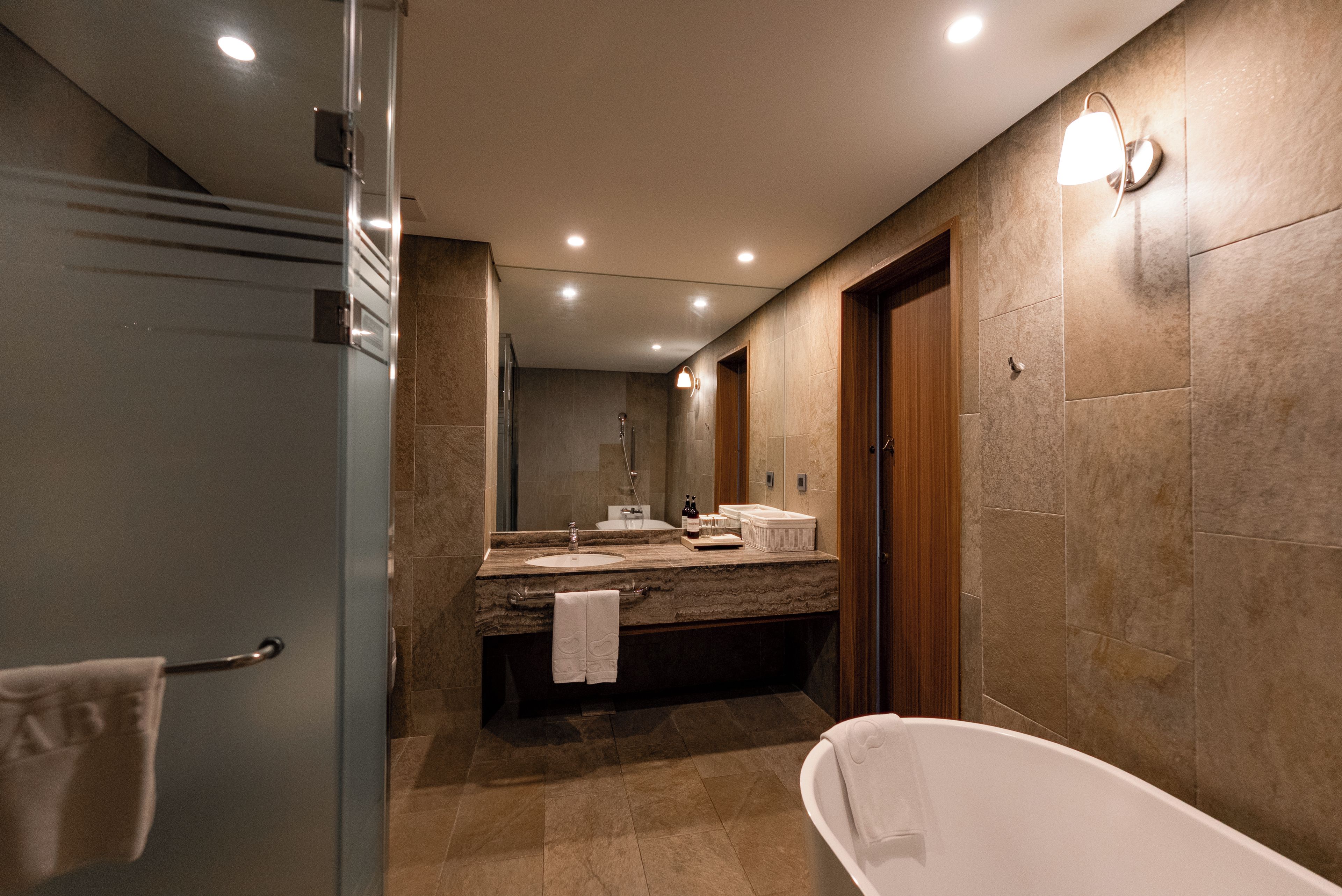 Une salle de bain moderne avec une baignoire sur pieds, un meuble-lavabo avec miroir et un espace douche.