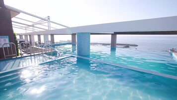Una piscina al aire libre, cabañas de piscina (de pago), sombrillas