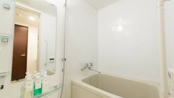 A bathroom with a bathtub, a glass shower enclosure, and a mirror.