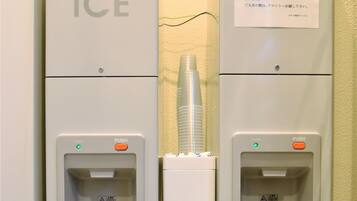Two ice dispensers labeled 'ICE' with a warning label and a push button.