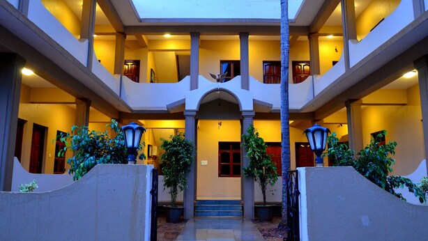 Un edificio de varios niveles con un patio central, que cuenta con una escalera que conduce a los pisos superiores y varios balcones.