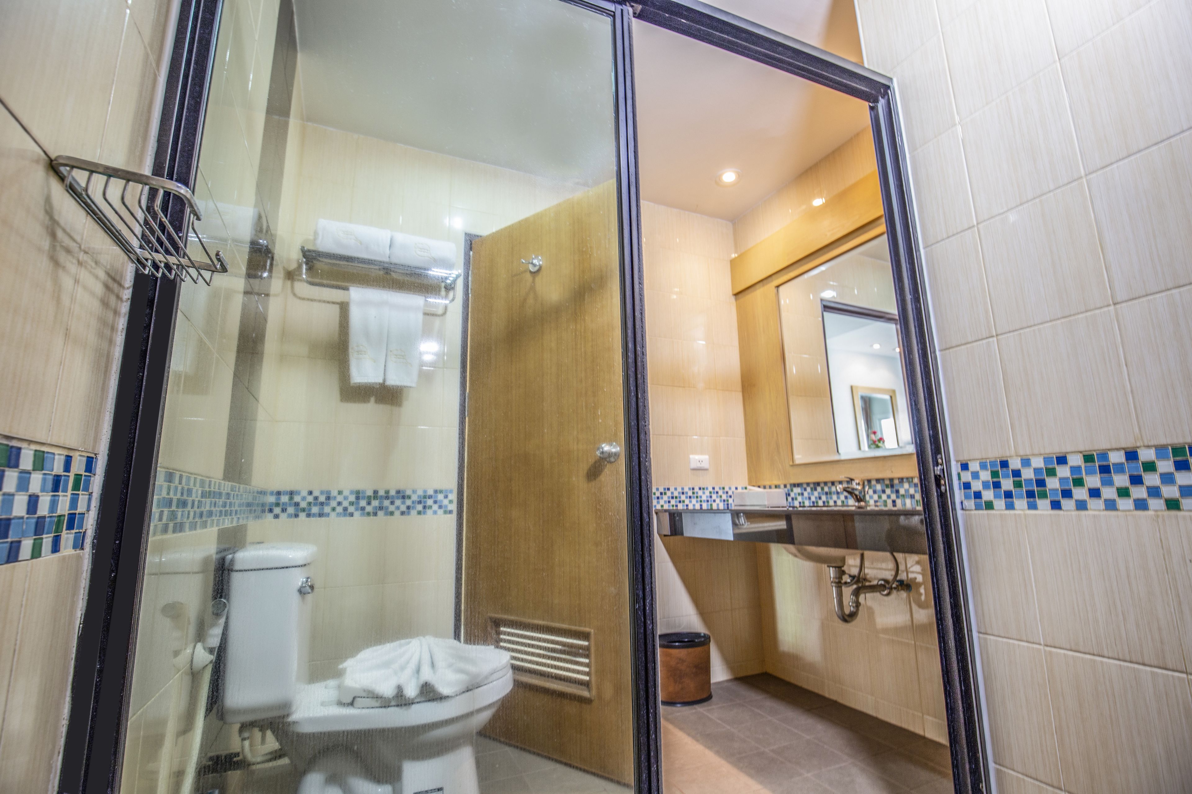 Ein Badezimmer mit Duschkabine aus Glas, Toilette und Waschbecken.