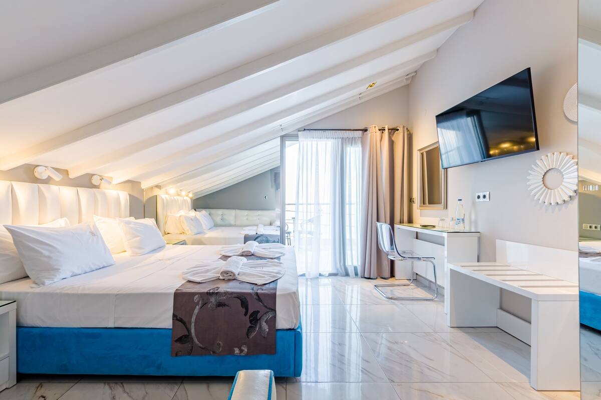 Una habitación de hotel moderna con una cama grande, un escritorio y una televisión.