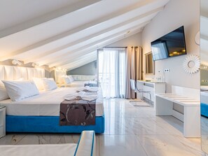 Ein modernes Hotelzimmer mit einem großen Bett, einem Schreibtisch und einem Fernseher.