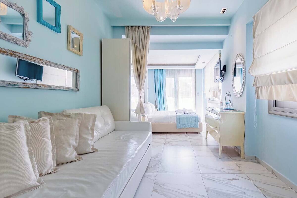 Un dormitorio con cama, tocador con espejo y televisor en la pared.