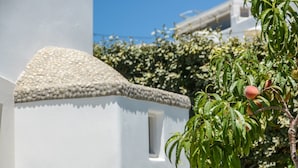 Un edificio blanco con techo texturizado y una ventana pequeña.