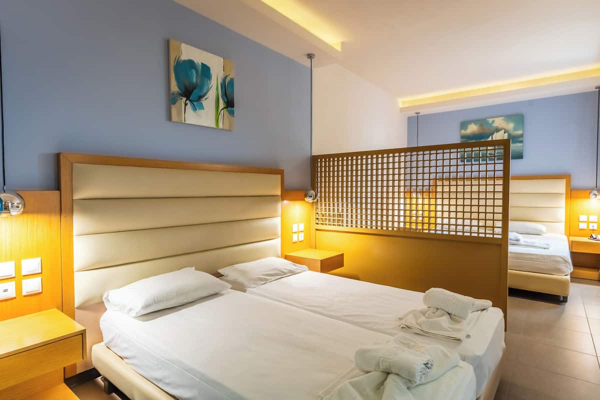 Una habitación de hotel con una cama grande, mesitas de noche y obras de arte en las paredes.