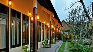 A building with a covered walkway and a garden. - Villa Hoa Su - Frangipani Village Resort (Da Nang)