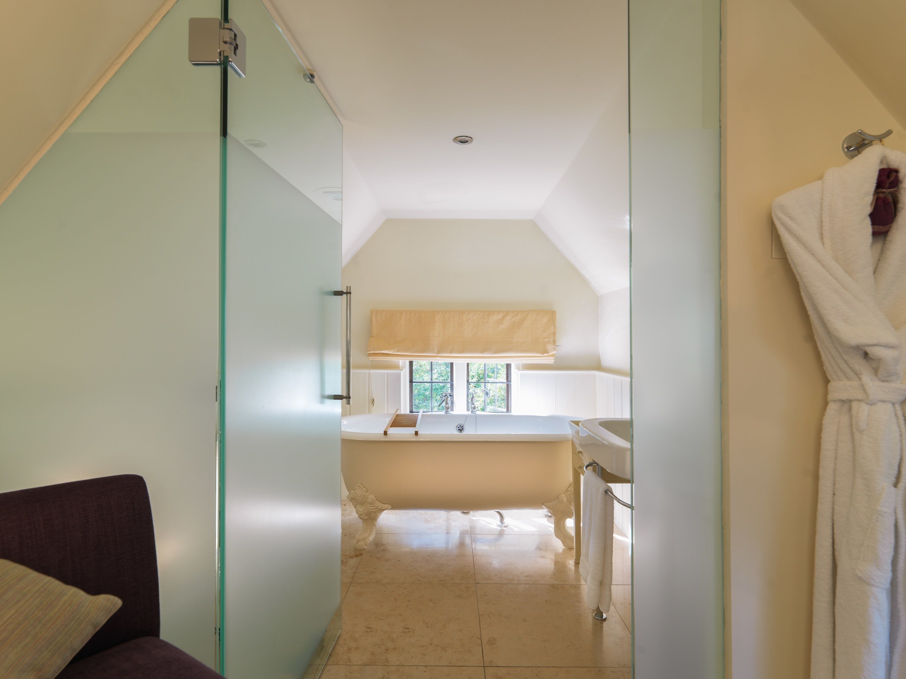 A modern bathroom with a bathtub, a glass shower enclosure, and a towel rack.
