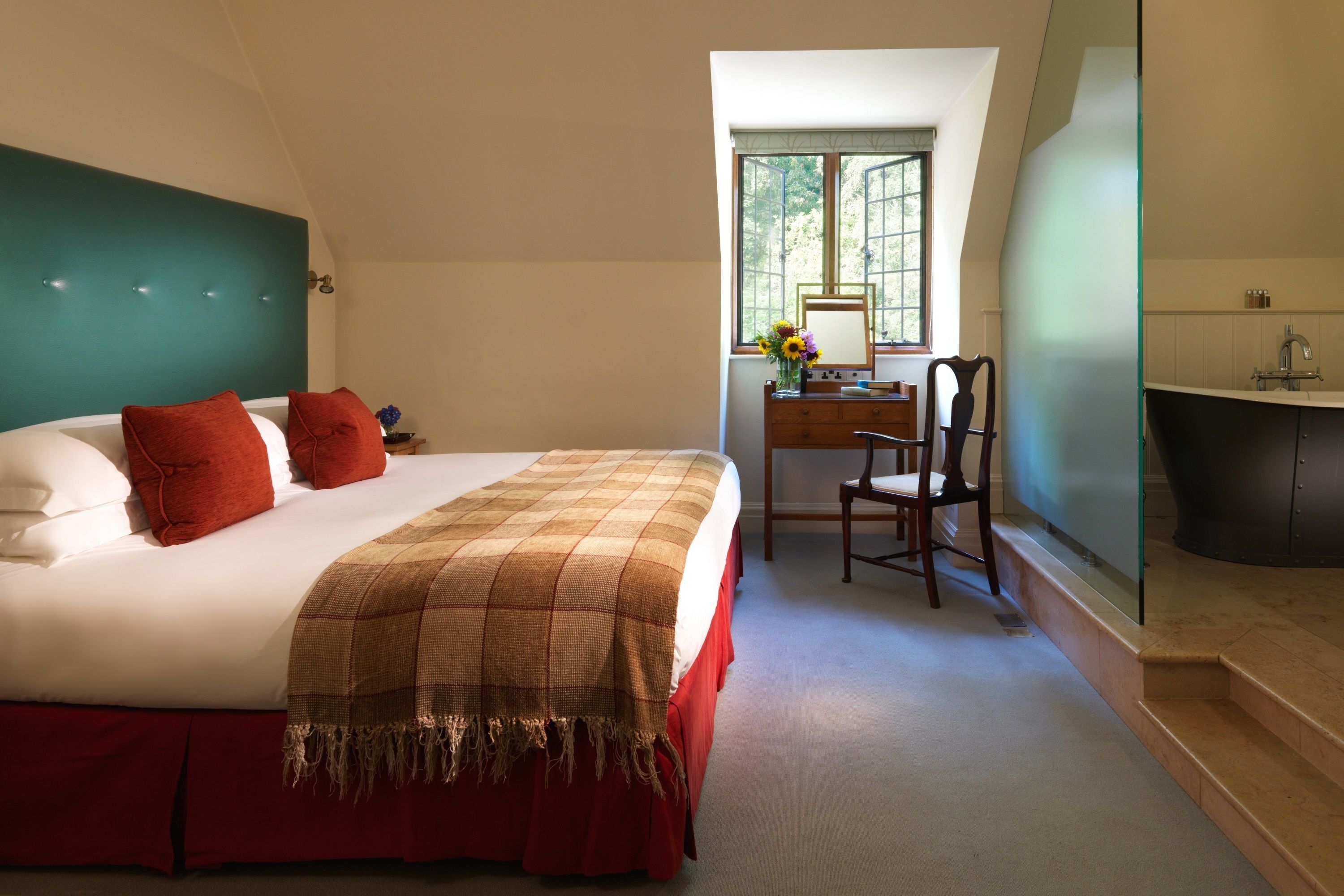 Een slaapkamer met een groot bed, een bureau en een badkamer.