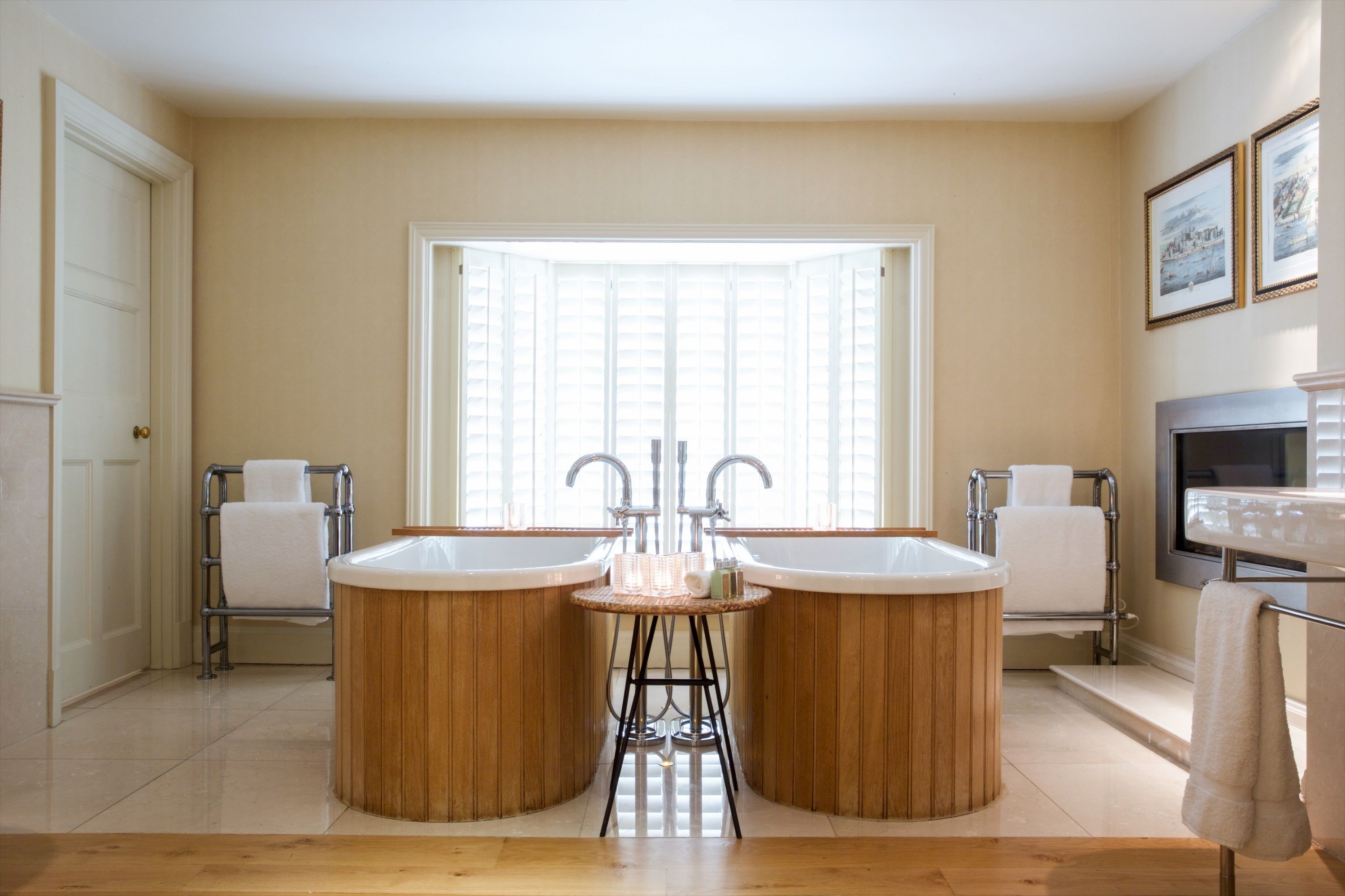 A bathroom with two large wooden tubs, a sink, and a window providing natural light.