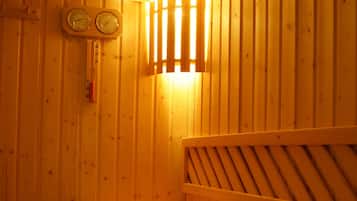 A wooden sauna with two benches, a wooden bucket, and a wall-mounted clock.