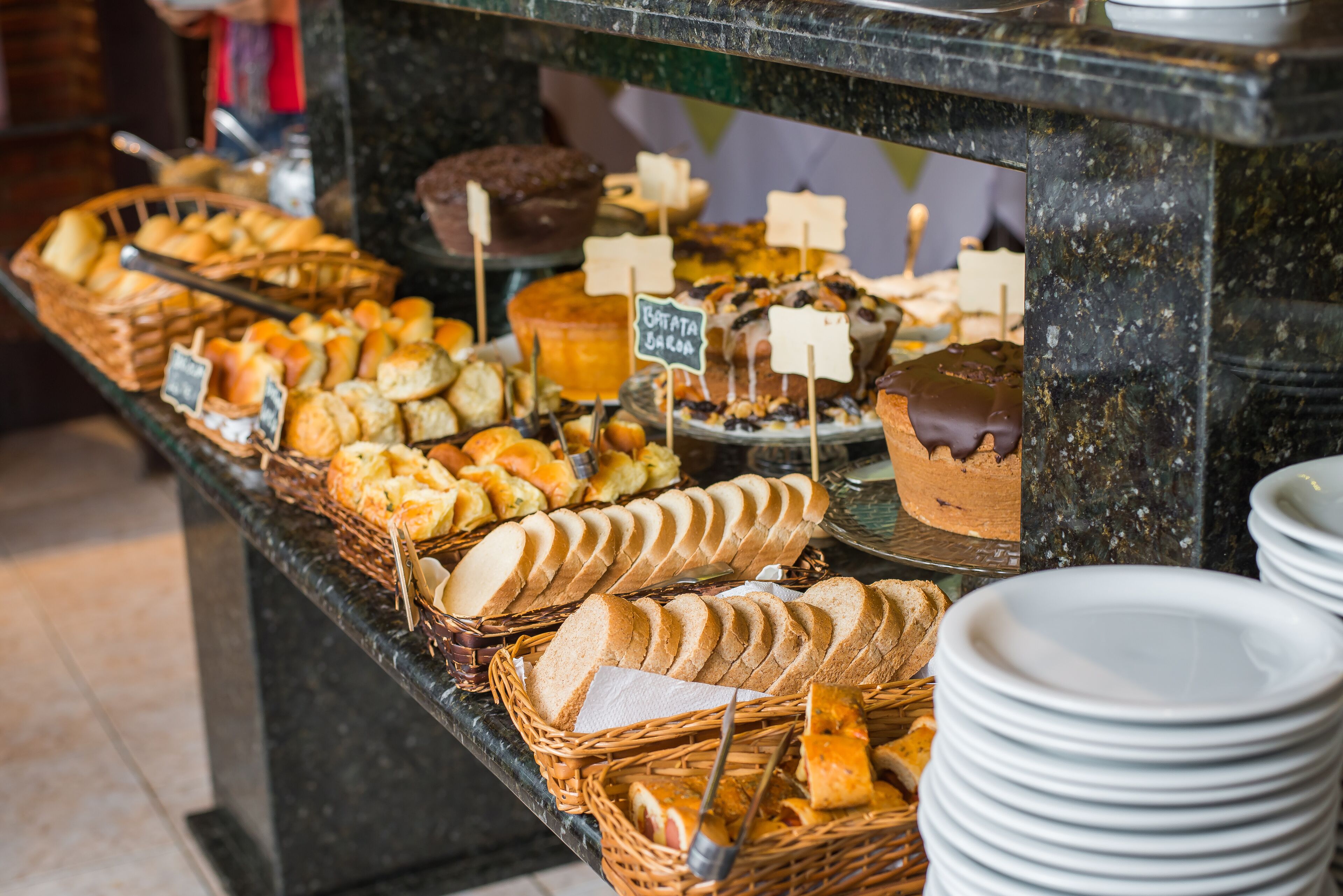 Een buffet met verschillende broden, gebak en desserts.