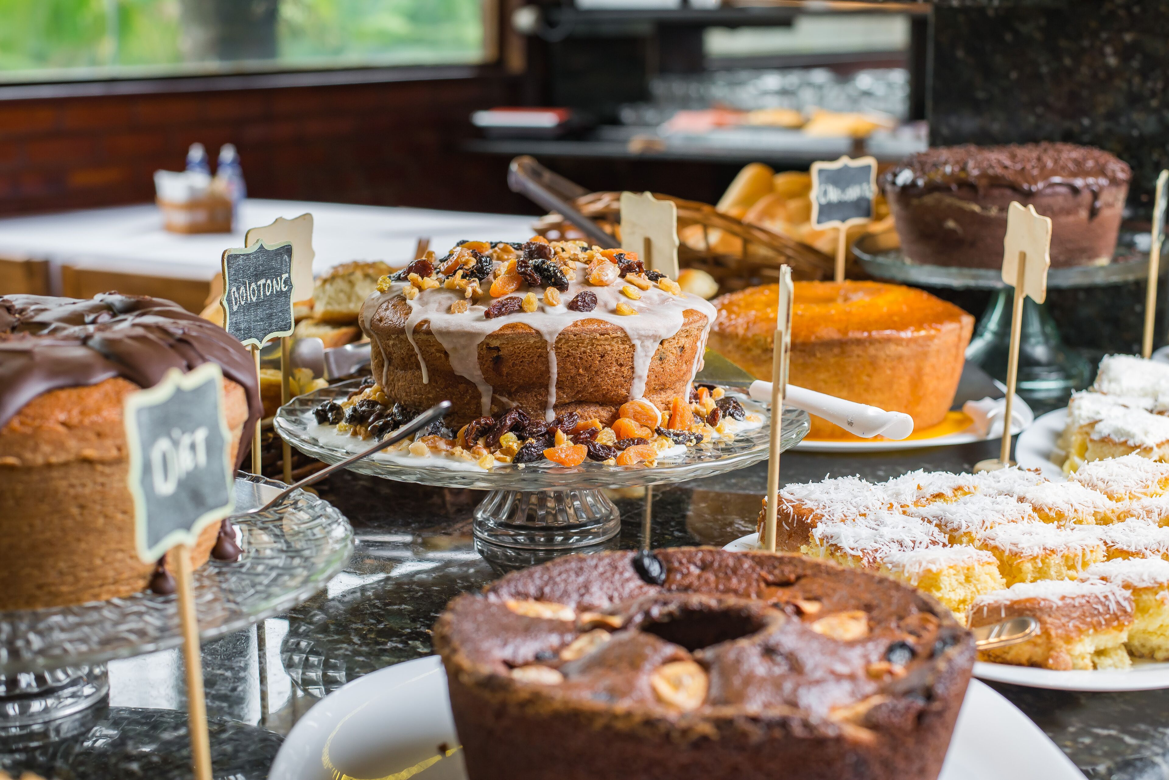 A variety of cakes and pastries displayed on a buffet table.